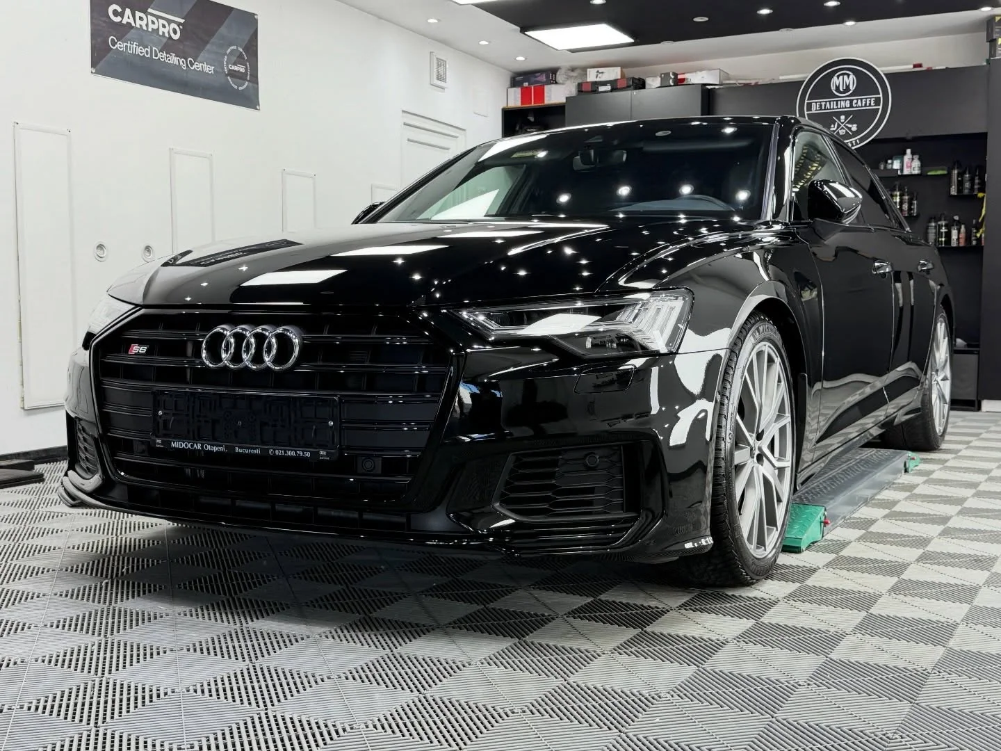 Audi S6 negru fotografiat frontal în atelier