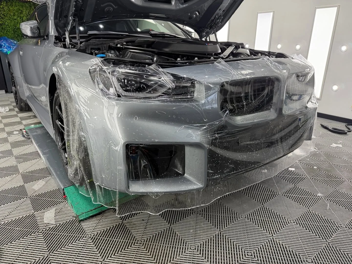 BMW M2 în timpul aplicării foliei PPF pe partea frontală