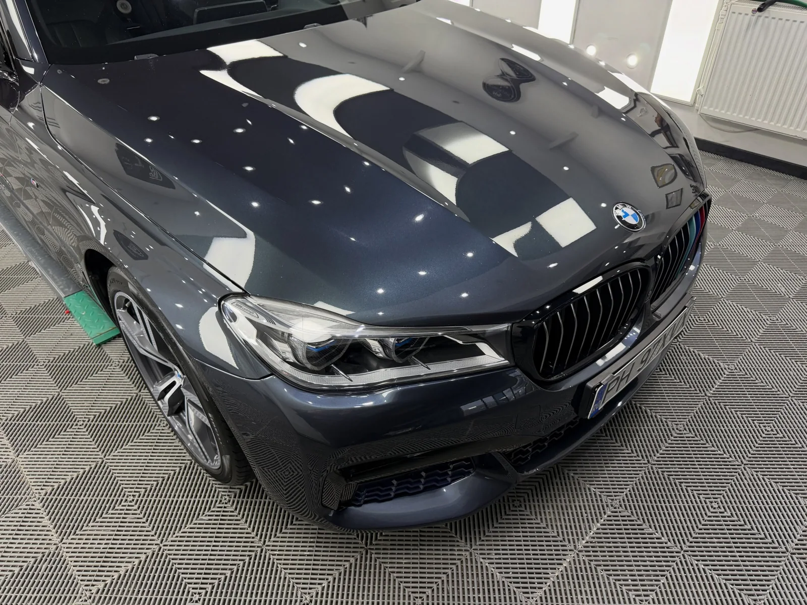 Reflexiile luminilor pe capota BMW-ului Seria 7 după corecția lacului