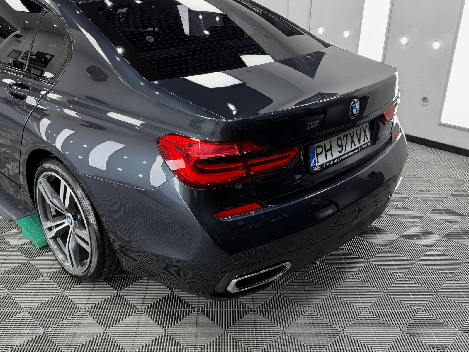 BMW Seria 7 gri, detaliu cu spatele și reflexiile din lac