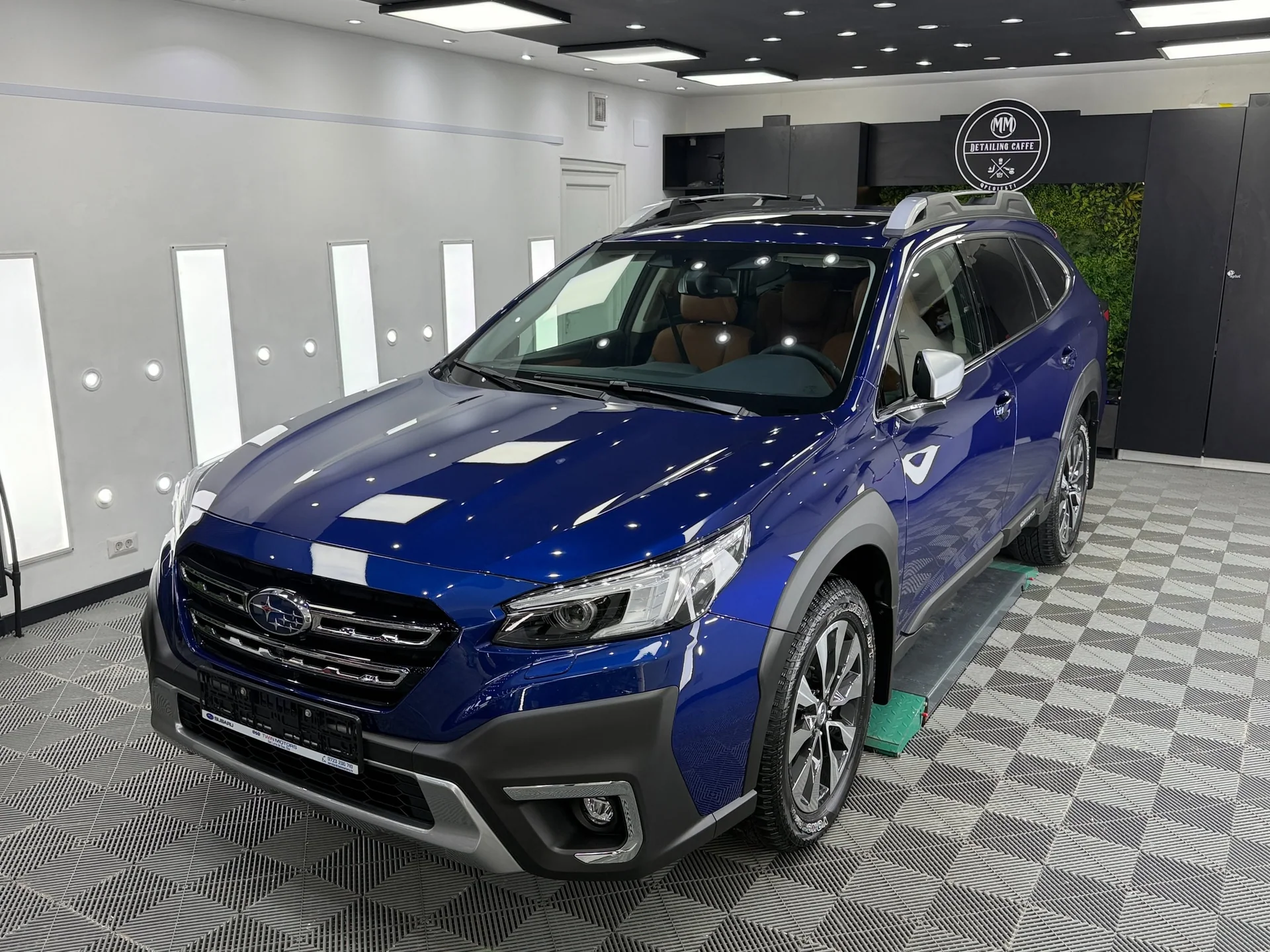 Subaru Outback albastru fotografiat din față în atelier