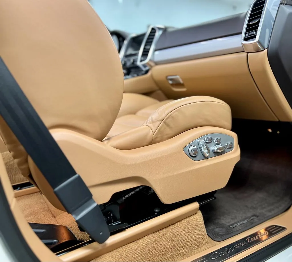 Scaun din piele maro și mochetă în habitaclul unui automobil
