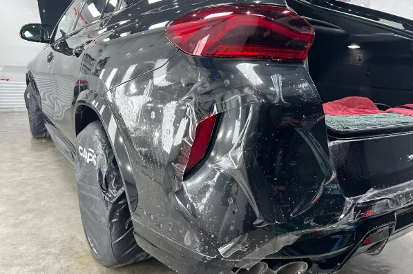 Folie PPF în curs de aplicare pe bara spate a unui BMW